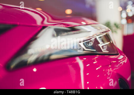 Nahaufnahme Scheinwerfer in der Luxury Pink auto Hintergrund. Moderne und teure sport auto Konzept. Stockfoto