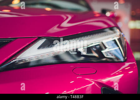 Nahaufnahme Scheinwerfer in der Luxury Pink auto Hintergrund. Moderne und teure sport auto Konzept. Stockfoto