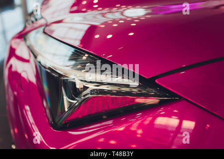 Nahaufnahme Scheinwerfer in der Luxury Pink auto Hintergrund. Moderne und teure sport auto Konzept. Stockfoto