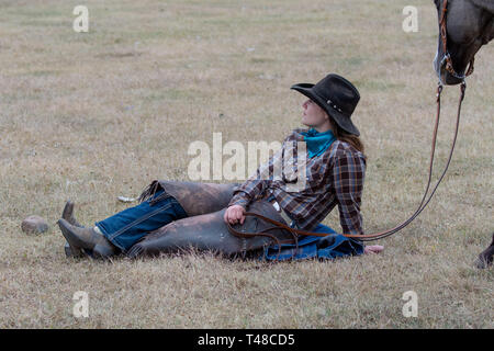 American Cowgirl mit Pferd nimmt einen Rest in das Feld Stockfoto