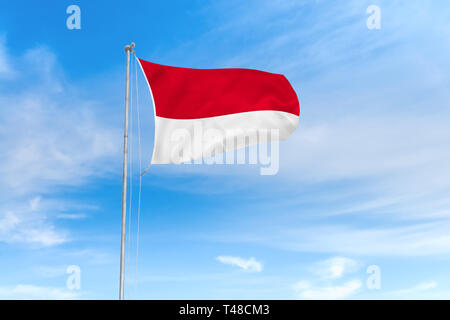 Indonesischen Flagge weht im Wind über blauen Himmel Hintergrund Stockfoto
