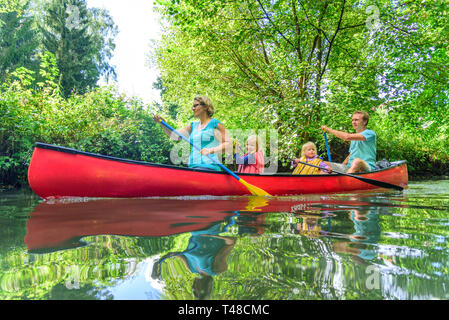 Familie im Kanu auf Tour auf einem idyllischen Fluss Stockfoto