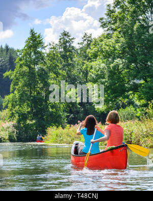 Zwei Frauen paddeln im Kanu auf dem kleinen Fluss Stockfoto