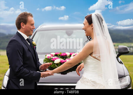 Braut und Bräutigam vor der Hochzeit Auto Stockfoto