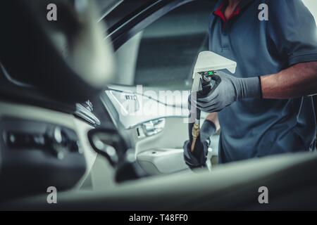 Professionelle Autoreinigung Service. Kaukasische Arbeiter mit Nass Trockensauger in den Händen der Vorbereitung für Dekostoffe Waschen. Stockfoto