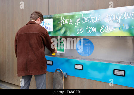 Eine Person füllt eine Wasserflasche aus einem öffentlichen Wasserbrunnen, der kohlensäurehaltiges Wasser in Paris, Frankreich abgibt Stockfoto