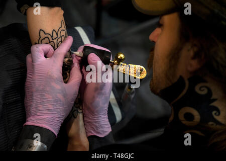 Ein Meister macht ein Tattoo an der Tattoo Festival in Moskau, Russland Stockfoto