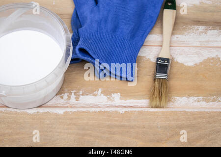 Pinsel und eine Dose mit weißer Farbe auf den Brettern, die Vorbereitung einer Holz- Oberfläche zum Lackieren Konzept. Vorbereitung für die Lackierung von Leiterplatten. Stockfoto