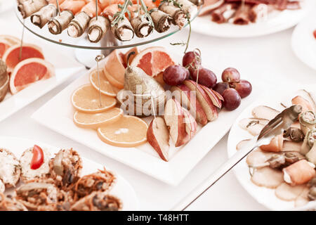 Platte mit Scheiben von verschiedenen Früchten auf dem festlichen Tisch Stockfoto