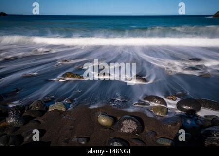 Schwarze Steine im Wave Naht am Strand, Langzeitbelichtung, Strand Playa de Vallehermoso, Gomera, Kanarische Inseln, Spanien Stockfoto