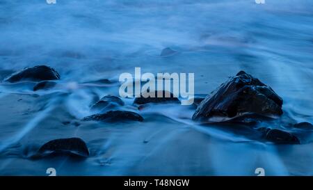 Schwarze Steine im Wasser am Strand, Meer, Langzeitbelichtung, La Gomera, Kanarische Inseln, Spanien Stockfoto