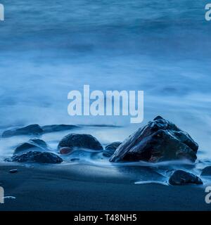 Schwarze Steine im Wasser am Strand, Meer, Surfen, Langzeitbelichtung, La Gomera, Kanarische Inseln, Spanien Stockfoto