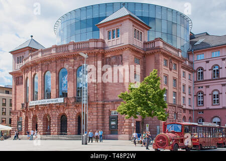 Mainz, Deutschland - 25. Mai 2017: Staatstheater Mainz an einem sonnigen Tag mit Menschen vor und eine Besichtigungstour Zug neben. Stockfoto