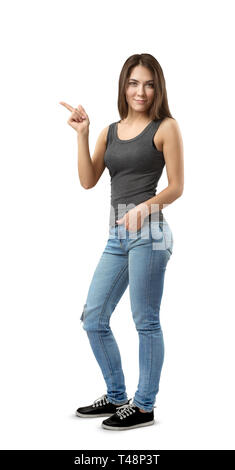 Junge Frau in ärmelloses Top und Jeans in Hälfte stehend - drehen Sie mit der linken Hand in der Tasche und rechts seitlich auf weißem Hintergrund hin isoliert. Stockfoto