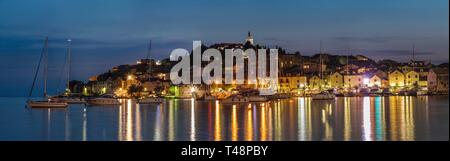 Blick auf die stadt mit Segelbooten und Lichter im Wasser widerspiegelt, Abendstimmung, Primosten, kroatische Adriaküste, Dalmatien, Kroatien Stockfoto