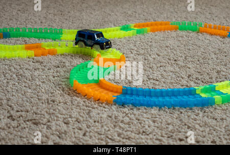 Bild von Spielzeug Auto Track mit Auto und bunten Titel Elemente auf dem Teppich Stockfoto