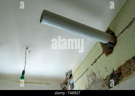 Offenes Abwasserrohr im Bau an den weißen Farbe bemalte Decke mit gemeinsamen Altmodische Grüne Lampe im Hintergrund an einem Apar Stockfoto