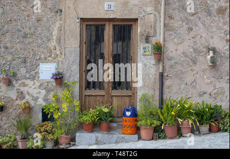 VALLDEMOSSA, MALLORCA, SPANIEN - 21. MÄRZ 2019: Blumen und Butan Gas Flasche vor der Tür in der Altstadt am 21. März 2019 in Valldemossa, Mallorca, Stockfoto