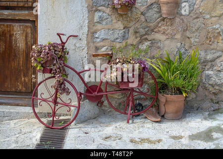 VALLDEMOSSA, MALLORCA, SPANIEN - 21. MÄRZ 2019: Red altes Fahrrad als Dekoration in der Altstadt am 21. März 2019 in Valldemossa, Mallorca, Balearen, Spanien. Stockfoto