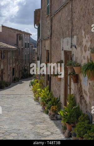 VALLDEMOSSA, MALLORCA, SPANIEN - 21. MÄRZ 2019: Sonnige Gasse und Blumendekorationen in der Altstadt am 21. März 2019 in Valldemossa, Mallorca, Balearen, Spanien. Stockfoto