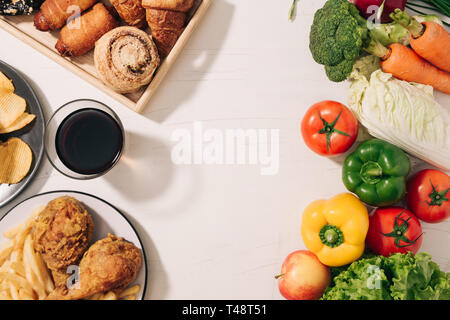 Wahl zwischen Obst und Süßigkeiten. Gesunde und ungesunde Nahrungsmittel. Stockfoto