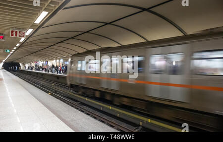 April 14, 2019. Griechenland, Athen. U-Bahnhof im Zentrum der Stadt. Blur Zug in Bewegung in die Station, Fahrgäste auf dem Bahnsteig warten auf emb Stockfoto