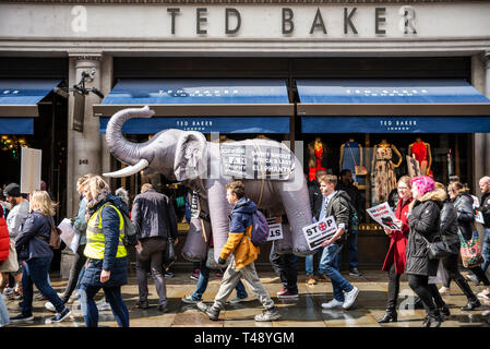 Die Demonstranten tragen einen aufblasbaren Elefanten durch die Straßen von London an einer Haltestelle Trophäenjagd und Handel mit Elfenbein Kundgebung in London, UK. Vorbei an Ted Baker Stockfoto