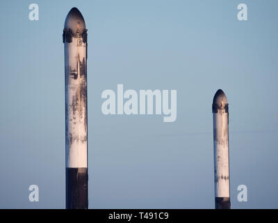 Zwei SpaceX Falcon Schwere wiederverwendbare Rocket Booster auf dem Landeplatz nach Durchführung der saudi-arabischen Arabsat 6A communications Satelliten in eine Erdumlaufbahn vom Kennedy Space Center und dann wieder April 11, 2019 in Cape Canaveral in Florida zu landen. Dies ist der erste kommerzielle Start der massiven 27-Motor Koloss, der derzeit leistungsstärkste Rakete jetzt auf der Erde. Stockfoto