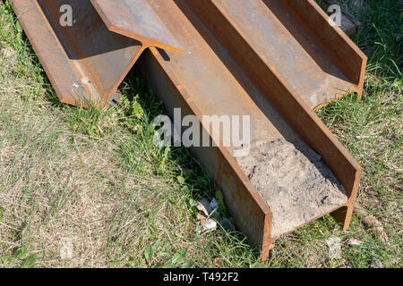 Groß, Stahl I-Abschnitte auf der Baustelle. Schlecht gespeichert Baustoffe. Saison der Feder. Stockfoto