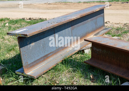 Groß, Stahl I-Abschnitte auf der Baustelle. Schlecht gespeichert Baustoffe. Saison der Feder. Stockfoto