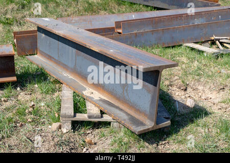 Groß, Stahl I-Abschnitte auf der Baustelle. Schlecht gespeichert Baustoffe. Saison der Feder. Stockfoto