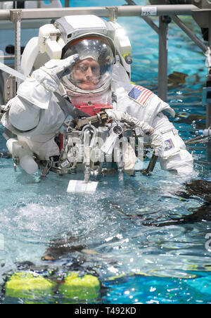 Commercial Crew Programm Astronauten Mike Fincke begrüßt, wie er in den Pool im Neutral Buoyancy Laboratory abgesenkt für ISS EVA Training in Vorbereitung auf die künftige Außenbordaktivitäten während der Internationalen Raumstation am Johnson Space Center Februar 1, 2019 in Houston, Texas an Bord. Stockfoto