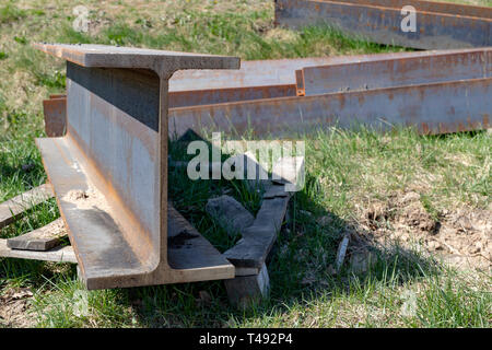 Groß, Stahl I-Abschnitte auf der Baustelle. Schlecht gespeichert Baustoffe. Saison der Feder. Stockfoto