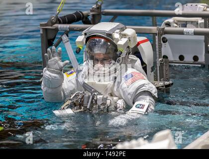 Boeing Commercial Crew Programm astronaut Josh Cassada Wellen vor dem Eintritt in das Schwimmbad im Neutral Buoyancy Laboratory für ISS EVA Training in Vorbereitung auf die künftige Außenbordaktivitäten während der Internationalen Raumstation am Johnson Space Center April 12, 2019 in Houston, Texas an Bord. Stockfoto