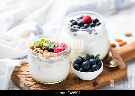 Natürliche griechischer Joghurt mit frischen Beeren und Müsli im Glas. Gesunde Ernährung, gesunde Lebensweise, sportliche Fitness Essen Menü Konzept Stockfoto