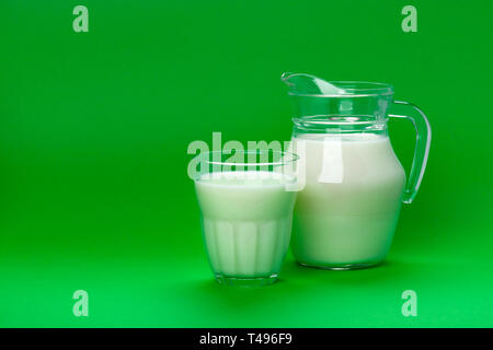 Glas und Glas Milch auf grünem Hintergrund mit Kopie Platz für Text isoliert, milchprodukt Konzept Stockfoto