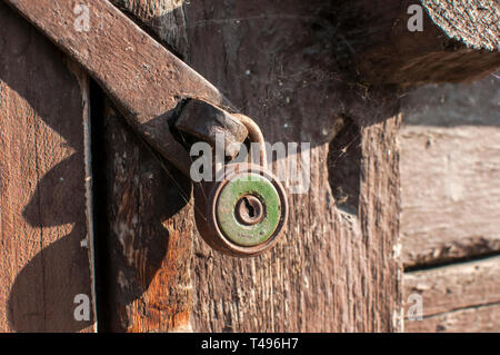 Alte vintage verwitterten gunge Vorhängeschloss closeup auf Holz- Hintergrund gesperrt Stockfoto