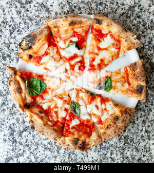 Blick von oben auf die Scheiben Pizza Margherita auf Marmor tisch. Stockfoto