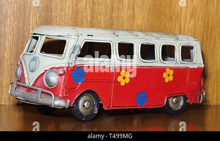 Altes Blechspielzeug, hier einen roten VW-Bus oder Auto mit Blumen bemalt Stockfoto