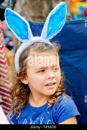 Ein Mädchen trägt bunny Ohren während einer Gemeinschaft Ostereiersuche am Langan Park, April 13, 2019 in Mobile, Alabama. Stockfoto