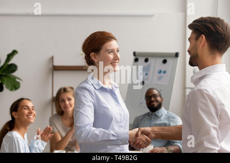 Gerne weibliche Mitarbeiter intern Handshake hilfsbereit Chef belohnt gefördert Stockfoto