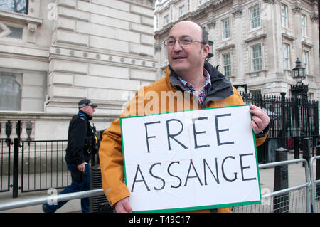 Whitehall, Downing Street. Ein einsamer Demonstrant hält ein Schild mit der Aufschrift "Freie Assange", dem Tag nach Julian Assange wurde in der Ecuadorianischen Embass verhaftet Stockfoto