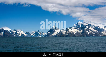 Schöne Panoramasicht auf South Georgia Berge und Küste vom Meer, Atlantik, Schnee coved Berge, blauer Himmel und weiße Wolken Stockfoto