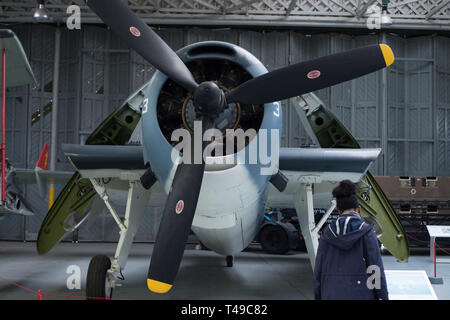 Besucher suchen Bei Grumman TBM-3 Avenger. Das Flugzeug ist im Imperial War Museum Duxford in England. Stockfoto