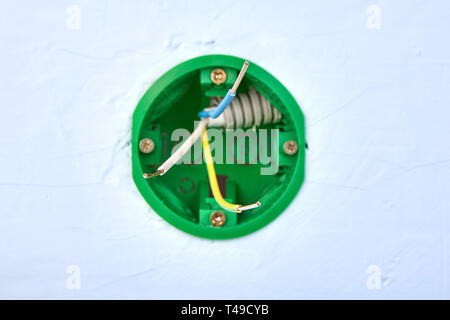 Runde Schaltkasten für Wand Lichtschalter mit Kupfer Drähte im Inneren, elektrische Installation arbeiten. Stockfoto