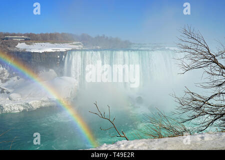 NIAGARA FALLS, NY-27 Mar 2019 - Blick auf einen Regenbogen über gefrorenes Eis und Schnee auf dem Niagara River und Niagara Falls im März 2019. Stockfoto