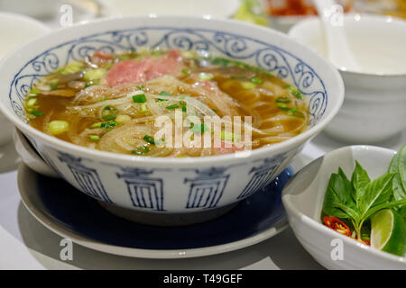 Reis Nudeln mit in Scheiben geschnittenen rohes Rindfleisch in Kalbfleisch (vietnamesische Nudelsuppe pho Rindfleisch) Stockfoto