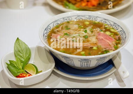 Reis Nudeln mit in Scheiben geschnittenen rohes Rindfleisch in Kalbfleisch (vietnamesische Nudelsuppe pho Rindfleisch) Stockfoto