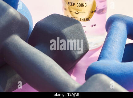 Eine Auswahl an Hanteln Kettlebells und eine Flasche frisches Wasser mit Limette und Zitrone Bestandteile sein. Stockfoto