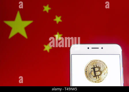 April 6, 2019 - Hongkong - In diesem Foto, Bild a cryptocurrency electronic cash Bitcoin Logo auf einem Android mobiles Gerät mit der Volksrepublik China Flagge im Hintergrund zu sehen ist. (Bild: © Budrul Chukrut/SOPA Bilder über ZUMA Draht) Stockfoto